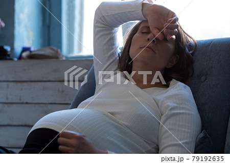 Pregnant woman resting at home being tired of heat 79192635