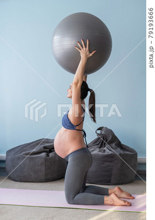 Pregnant caucasian woman on fitness with a ball. Yoga for expectant mothers. Girl in the classroom in preparation for childbirth. Pilates in the last trimester. 79193666