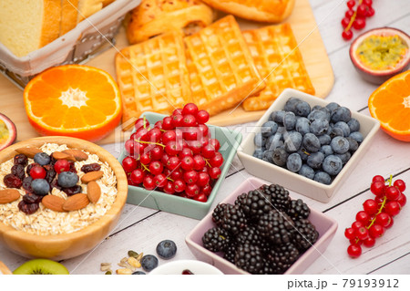Breakfast Served in the morning with Butter bread and corn flakes Whole grains and raisins with milk in cups and Strawberry, Blueberry, Raspberry, Kiwi, Fresh Orange on the breakfast table. Breakfast Served in the morning with Butter bread and corn flakes Whole grains and raisins with milk in cups and Strawberry, Blueberry, Raspberry, Kiwi, Fresh Orange on the breakfast table. 79193912