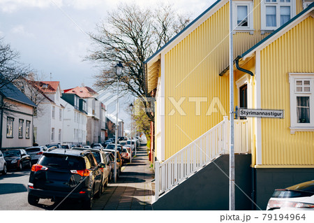 Yellow house with stairs and white railings, on the street in Reykjavik, the capital of Iceland. Cars parked along the road. Yellow house with stairs and white railings, on the street in Reykjavik, the capital of Iceland. Cars parked along the road. 79194964
