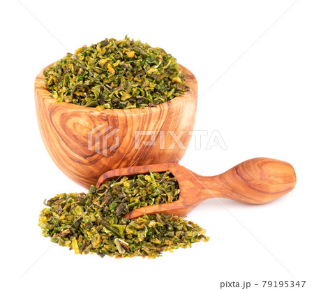 Dried green paprika flakes with seeds in olive bowl and scoop, isolated on white background. Chopped jalapeno, habanero or chilli pepper. Spices and herbs. Dried green paprika flakes with seeds in olive bowl and scoop, isolated on white background. Chopped jalapeno, habanero or chilli pepper. Spices and herbs. 79195347