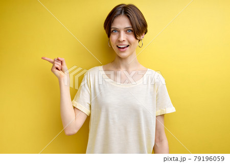 Pretty good-looking positive adult woman pointing finger at side copy space for advertisement 79196059
