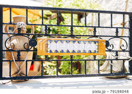 Blank sign on a forged metal fence against the background of clay jugs 79198048