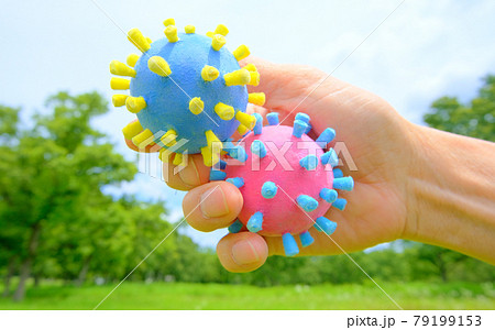 コロナ菌模型を手に持って背景を森林としてアフターコロナをイメージ コロナ菌模型を手に持って背景を森林としてアフターコロナをイメージ 79199153