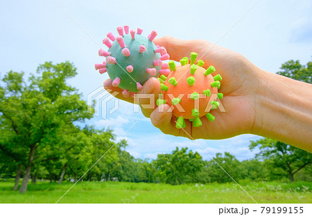コロナ菌模型を手に持って背景を森林としてアフターコロナをイメージ コロナ菌模型を手に持って背景を森林としてアフターコロナをイメージ 79199155