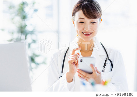 病院内でスマートフォンを見ている女性医師 79199180