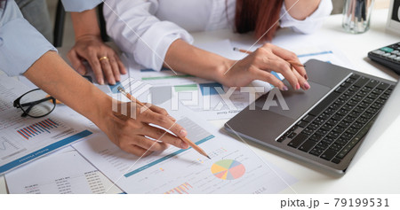 Close up business team using a calculator and laptop computer to calculate the numbers on his desk in a office Close up business team using a calculator and laptop computer to calculate the numbers on his desk in a office 79199531
