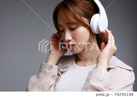 ヘッドフォンで音楽に聴き入る若い女性 ヘッドフォンで音楽に聴き入る若い女性 79200196