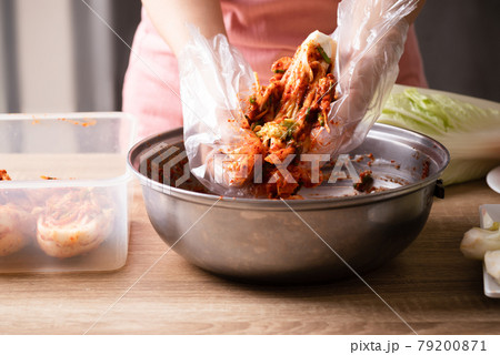 Woman making kimchi cabbage in a big bowl, Korean food 79200871