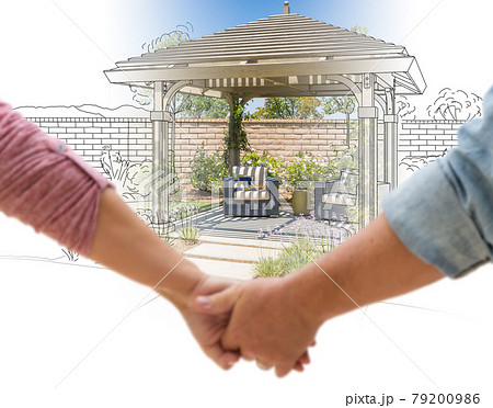 Couple Holding Hands Looking at Design Drawing and Photo of New Yard Pergola. Couple Holding Hands Looking at Design Drawing and Photo of New Yard Pergola. 79200986