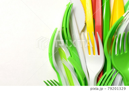 Pile of bright yellow, green and white plastic kitchenware single use appliances 79201329