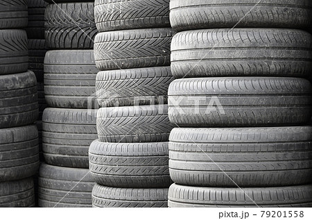 Old used tires stacked with high piles in secondary car parts shop garage 79201558