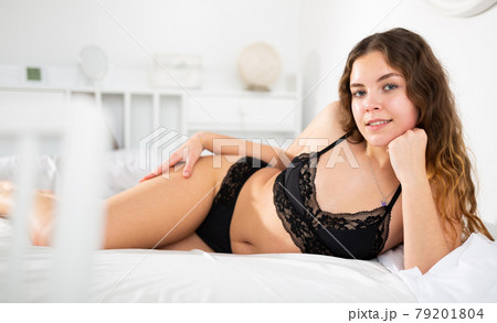 Sexy woman with long hair in underwear lying on bed 79201804