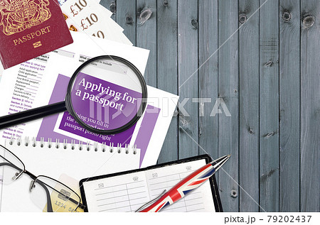 English violet guide Applying for a passport lies on table with office items. UK passport paperwork English violet guide Applying for a passport lies on table with office items. UK passport paperwork 79202437
