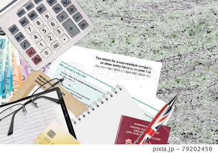 English form sa700 Tax return for a non-resident company or other entity liable to income tax from HM revenue and customs lies on table with office items. HMRC paperwork 79202456