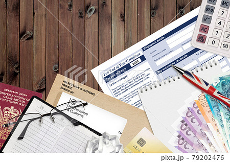 English Tax form P60 End of year certificate by HM revenue and customs lies on table with office items. HMRC paperwork and tax paying process in United Kingdom 79202476