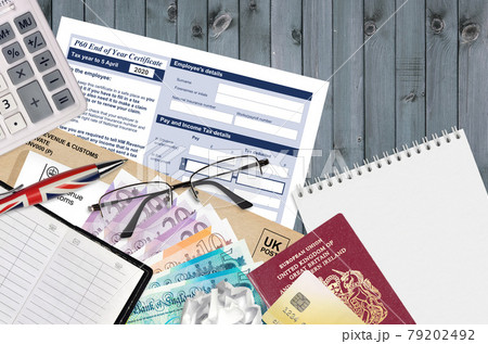 English Tax form P60 End of year certificate by HM revenue and customs lies on table with office items. HMRC paperwork and tax paying process in United Kingdom 79202492