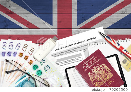 English form LS01 Lost or stolen british passport notification from HM passport office lies on table with office items. UK passport paperwork 79202500