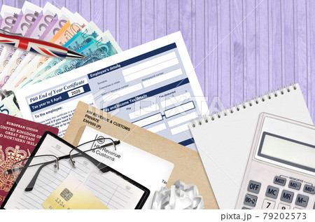 English Tax form P60 End of year certificate by HM revenue and customs lies on table with office items. HMRC paperwork and tax paying process in United Kingdom 79202573