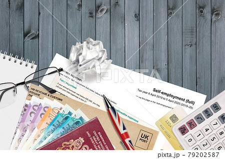 English Tax form sa103 Self-employment from HM revenue and customs lies on table with office items. HMRC paperwork and tax paying process in United Kingdom 79202587