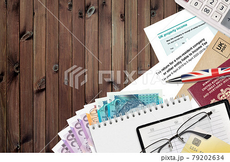 English form sa700 Tax return for a non-resident company or other entity liable to income tax from HM revenue and customs lies on table with office items. HMRC paperwork 79202634