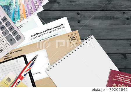 English Tax form sa108 Residence remittance basis etc from HM revenue and customs lies on table with office items. HMRC paperwork and tax paying process in United Kingdom 79202642