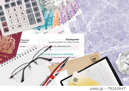 English Tax form sa102 Employment by HM revenue and customs lies on table with office items. HMRC paperwork and tax paying process in United Kingdom 79202647