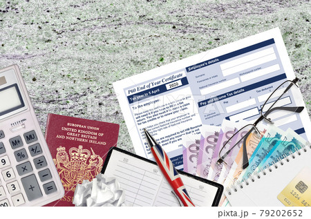English Tax form P60 End of year certificate by HM revenue and customs lies on table with office items. HMRC paperwork and tax paying process in United Kingdom 79202652
