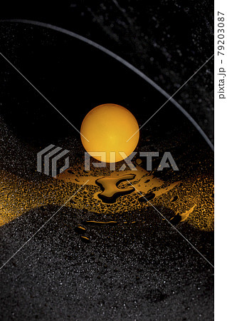 Abstract image with orange ball and water drops on reflective surface 79203087