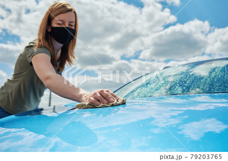 Hand cleaning modern blue car with microfiber cloth Hand cleaning modern blue car with microfiber cloth 79203765