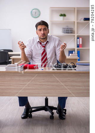 Young male employee suffering at workplace 79204285