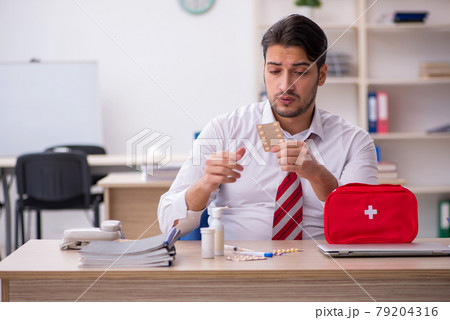 Young male employee suffering at workplace 79204316