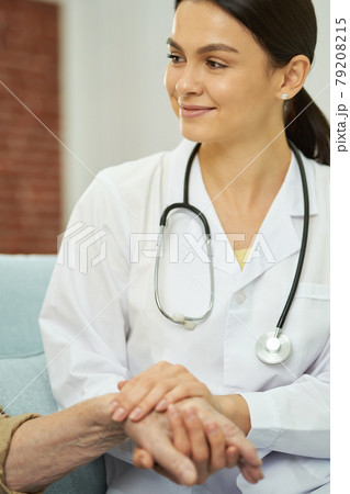 Smiling female doctor supporting old man during treatment Smiling female doctor supporting old man during treatment 79208215