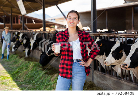 Young woman farmer working at dairy farm 79209409