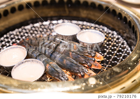 Japanese barbecue restaurant. Shrimp and scallops are heated on the grilled net. Japanese barbecue restaurant. Shrimp and scallops are heated on the grilled net. 79210176