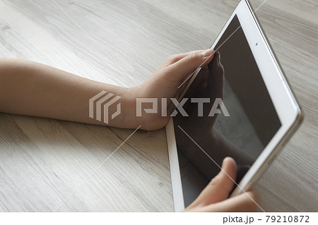タブレット端末を見ている子供 79210872