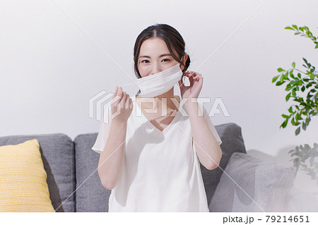 マスクを外す笑顔の若い女性 79214651