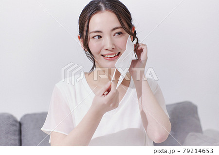 マスクを外す笑顔の若い女性 79214653