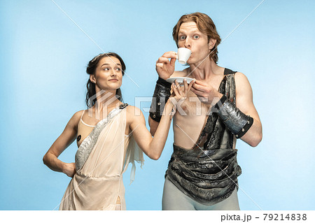 Coffee time. Young couple of ballet dancers in ancient Rome costums at blue studio. 79214838