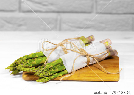 Bunches of Fresh Green asparagus in wooden desk on white background. Healthy vegetable diet. Vegetarianism. Vegetable wallpaper. 79218336