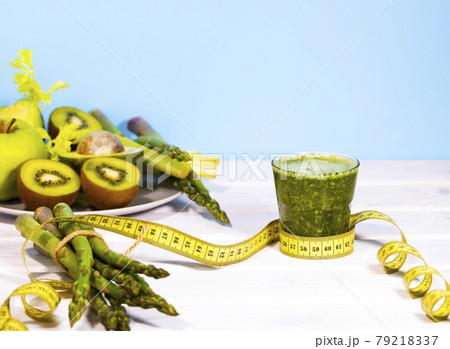 Ingridients for Smoothie of Fresh Green Vegetables and Fruits on Table. Equilibrium floating food. Healthy Alkaline diet. Balance. Copy Space. Vegetarianism. Measuring tape 79218337