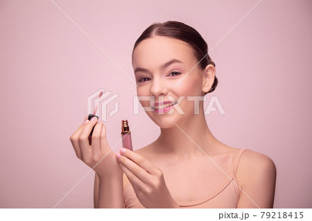 Portrait of beautiful young woman isolated on light pink studio background. Concept of female beauty, style, makeup Portrait of beautiful young woman isolated on light pink studio background. Concept of female beauty, style, makeup 79218415