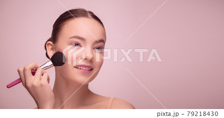 Portrait of beautiful young woman isolated on light pink studio background. Concept of female beauty, style, makeup Portrait of beautiful young woman isolated on light pink studio background. Concept of female beauty, style, makeup 79218430