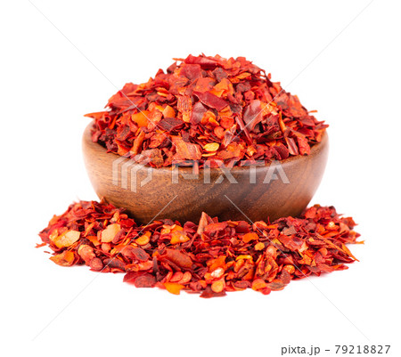 Dried red chili flakes in wooden bowl, isolated on white background. Chopped chilli cayenne pepper. Spices and herbs. 79218827