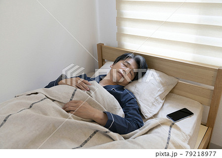 スマートホンをそばに置いて睡眠中の50代男性 寝顔 スマートホンをそばに置いて睡眠中の50代男性 寝顔 79218977