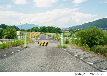 川沿いの道路の車止めポールに危険の看板がかかった風景 川沿いの道路の車止めポールに危険の看板がかかった風景 79218978