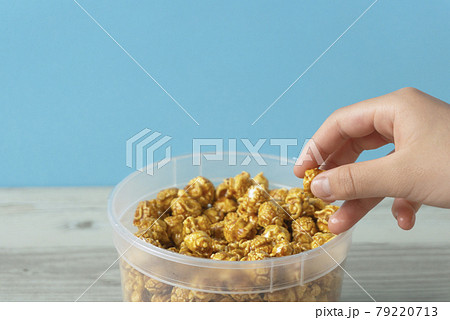 テーブルの上にあるポップコーンを食べている子供	 79220713