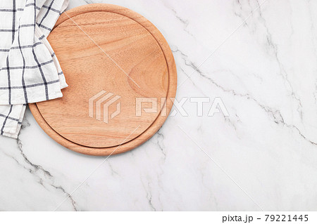 Empty wooden pizza platter with napkin and rolling pin set up on marble stone kitchen table. 79221445