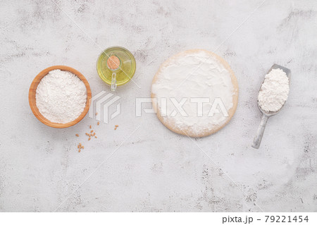 The ingredients for homemade pizza dough with wheat ears ,wheat flour and wheat grains set up on white concrete background. The ingredients for homemade pizza dough with wheat ears ,wheat flour and wheat grains set up on white concrete background. 79221454