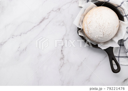 Fresh raw homemade yeast dough resting in cast iron skillet on marble table flat lay.. Fresh raw homemade yeast dough resting in cast iron skillet on marble table flat lay.. 79221476